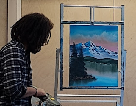 Certified instructor Nate Miller painting a mountainscape