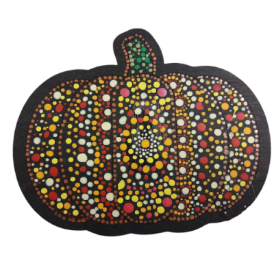 a wooden pumpkin covered in different colored paint dots.