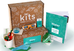 The learning lunchbox water edition boox with glasses, notebook, scissors, and pencils spread out around it.